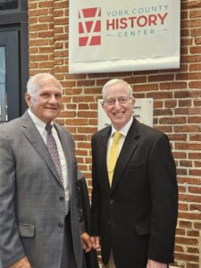 Dennis Baughman and JT Hand pose under History Center sign