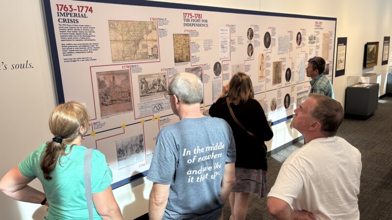 Revolutionary York exhibit visitors look at large timeline