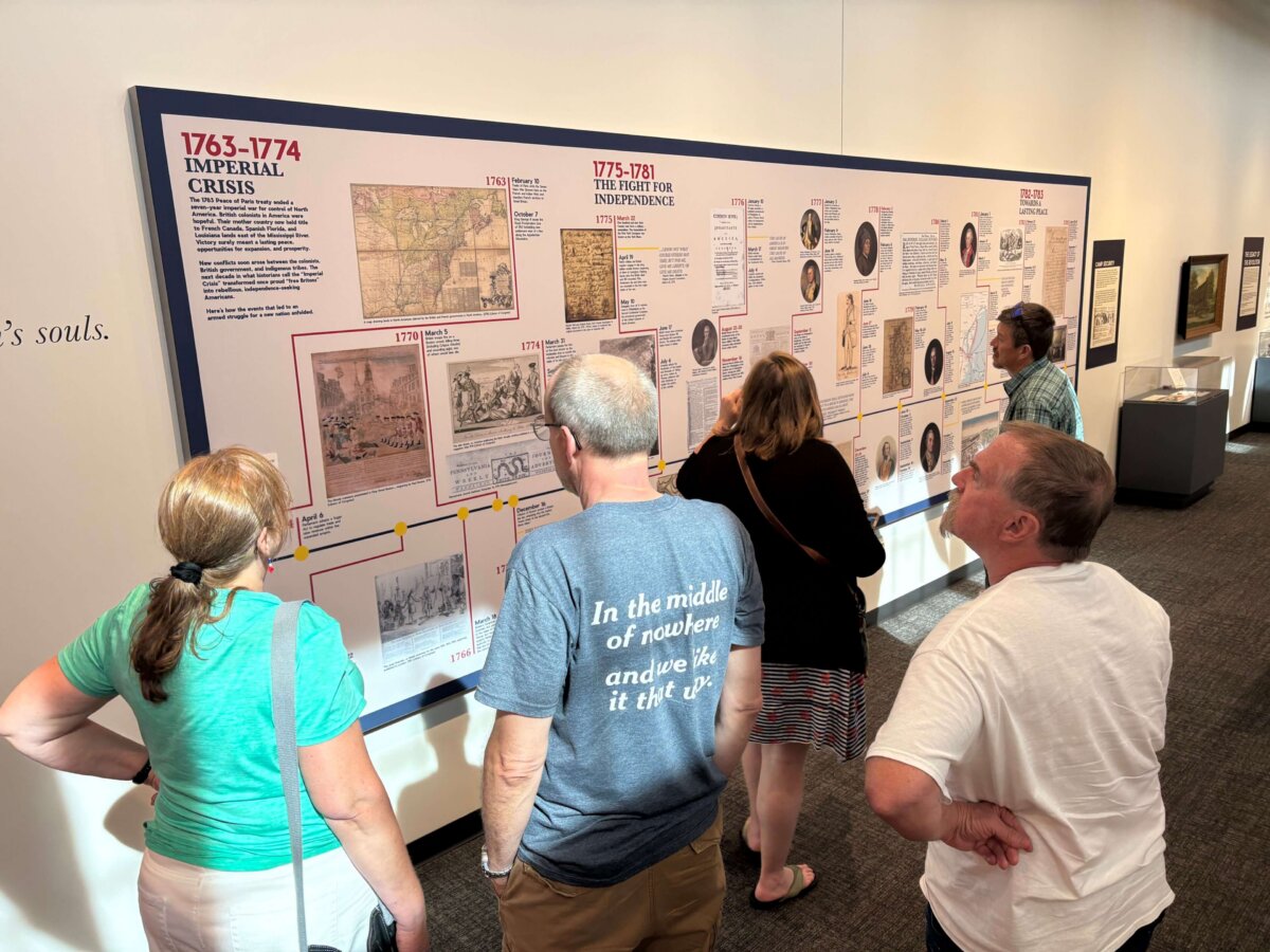Revolutionary York exhibit visitors look at large timeline