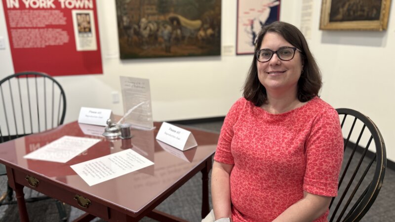 Nicole Smith, seated at a desk in the Revolutionary York exhibit