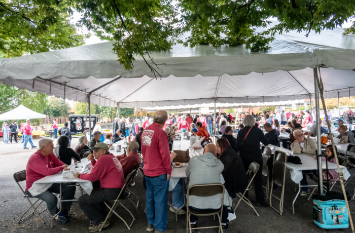 people seated at tables under a tent at the 2025 Oyster Festival