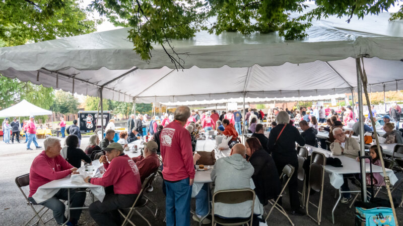 people seated at tables under a tent at the 2025 Oyster Festival
