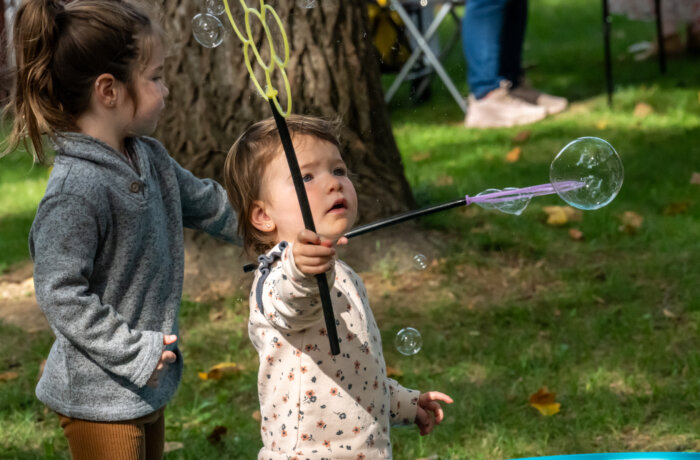young child playing with bubble wand